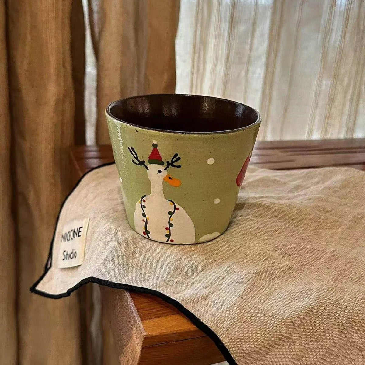 Handmade ceramic mug with festive reindeer design, perfect for holiday coffee or tea